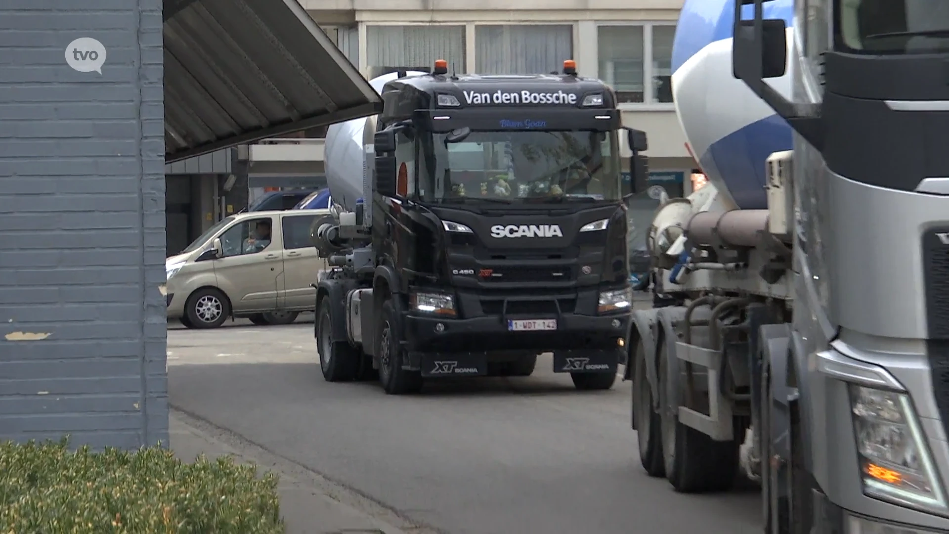 De klok rond rijden betonmixers aan en af om vloerplaat te gieten in Temse