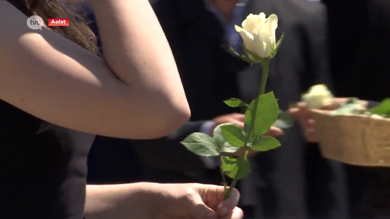 Familie en vrienden leggen witte rozen op kist