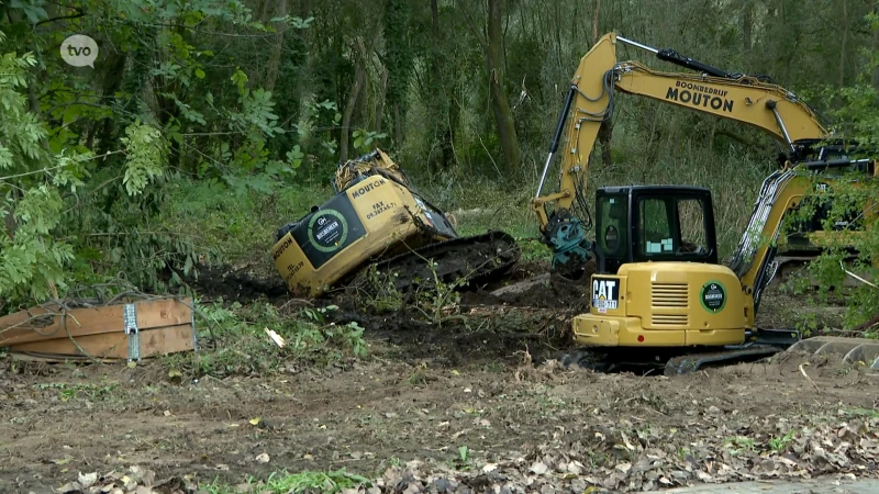 Graafmachine rijdt zich vast en kantelt bij werken in een bos in Denderleeuw